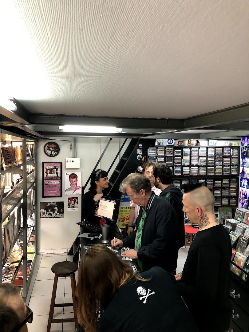 People gathered at a counter in a record store, with shelves of records in the background.