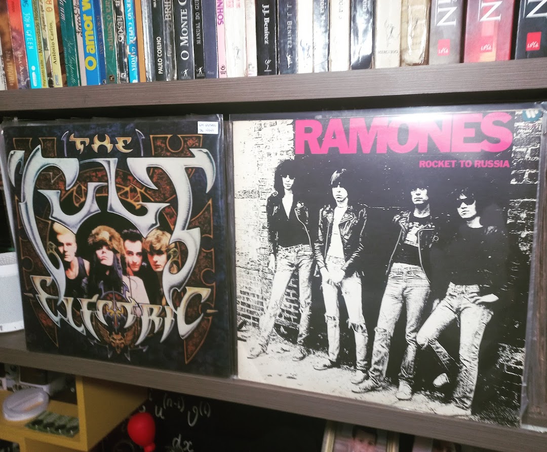 Vinyl records from bands The Cult and Ramones displayed on a shelf.