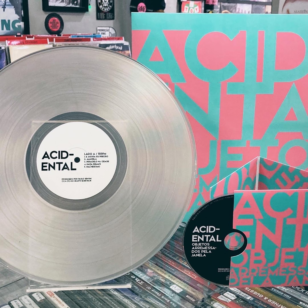 A clear vinyl record and CD with colorful album art from the band Acid-ental.