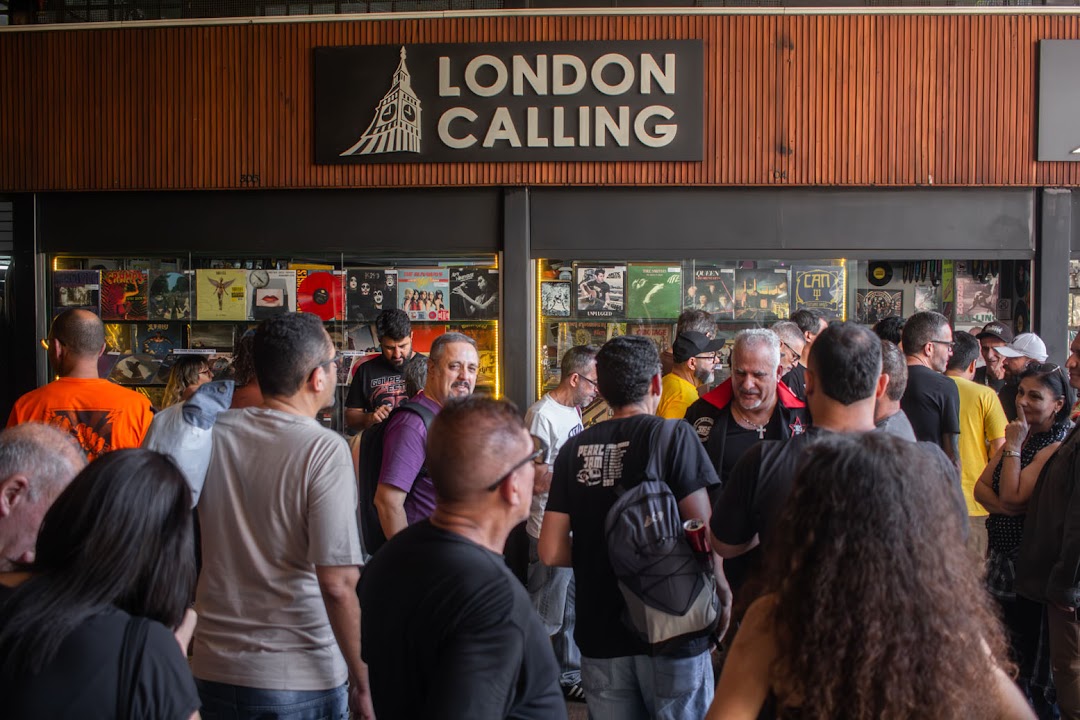 A crowd of people gathered outside a record store with a prominent "London Calling" sign.