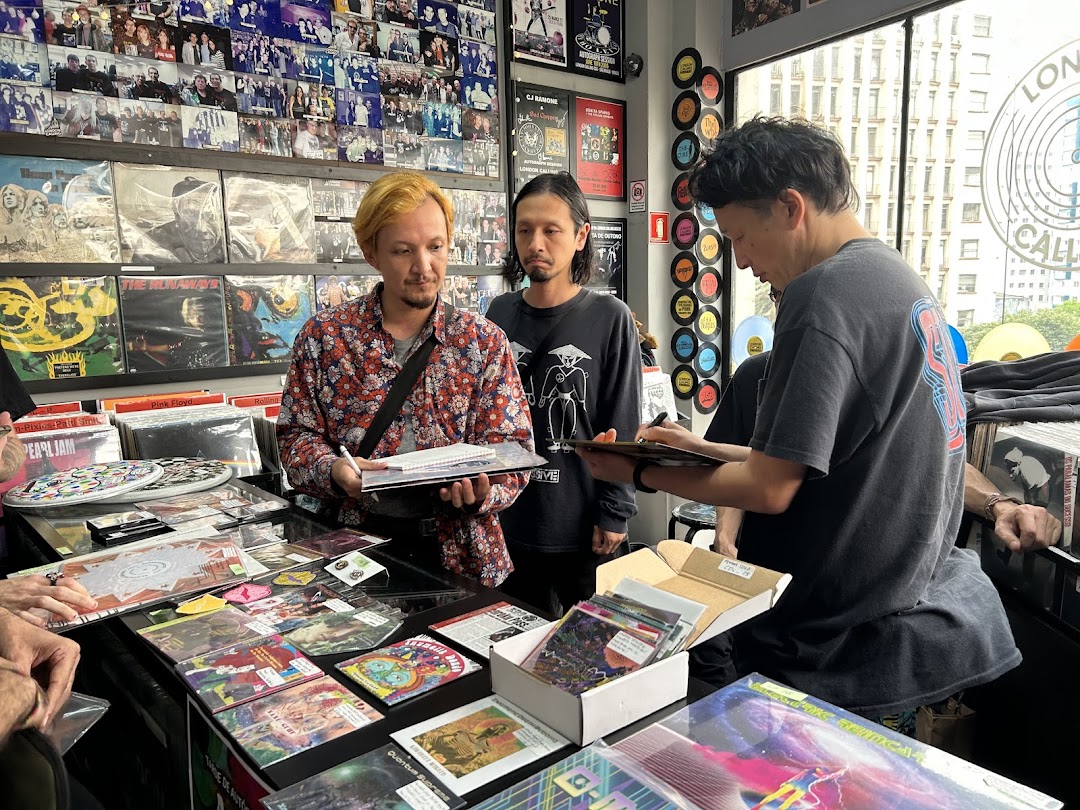 People browsing and interacting with records and merchandise in a record store.