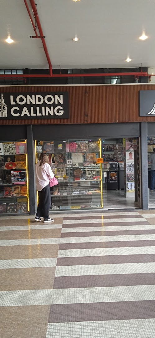 A person stands outside a record store called London Calling, browsing its vinyl collection.
