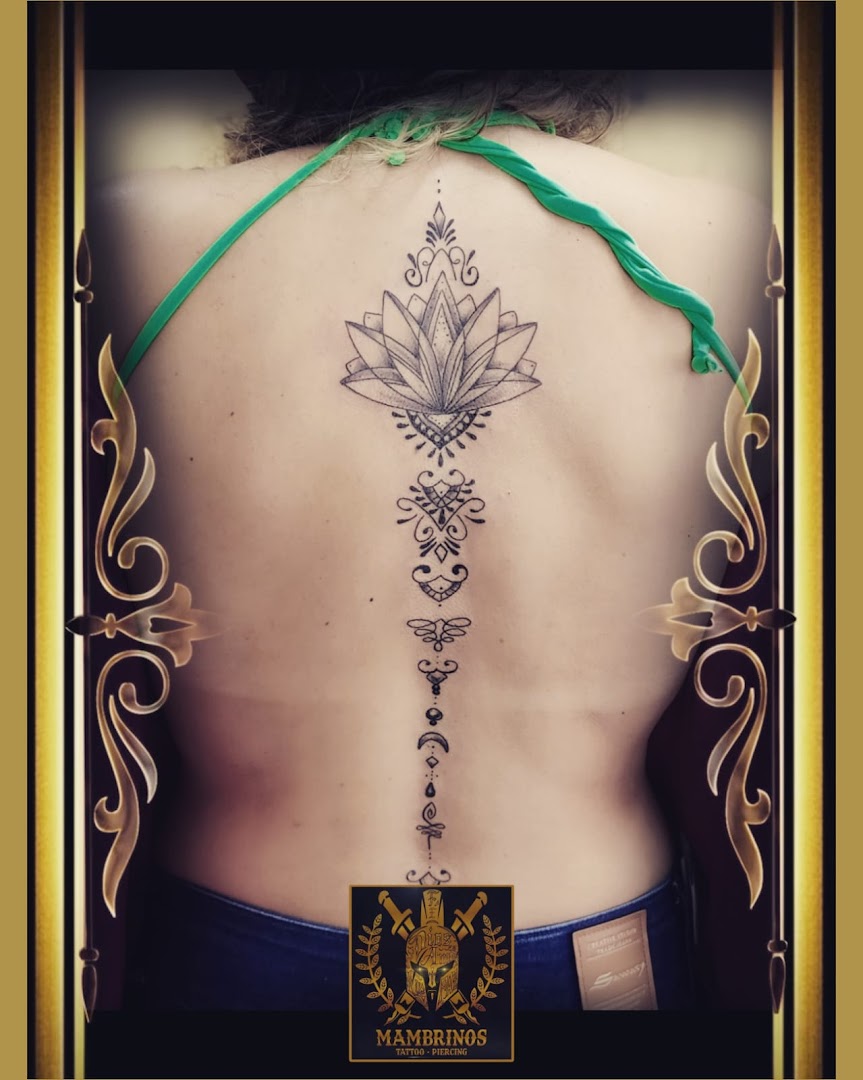A person's back displays an intricate lotus and celestial-themed tattoo design.