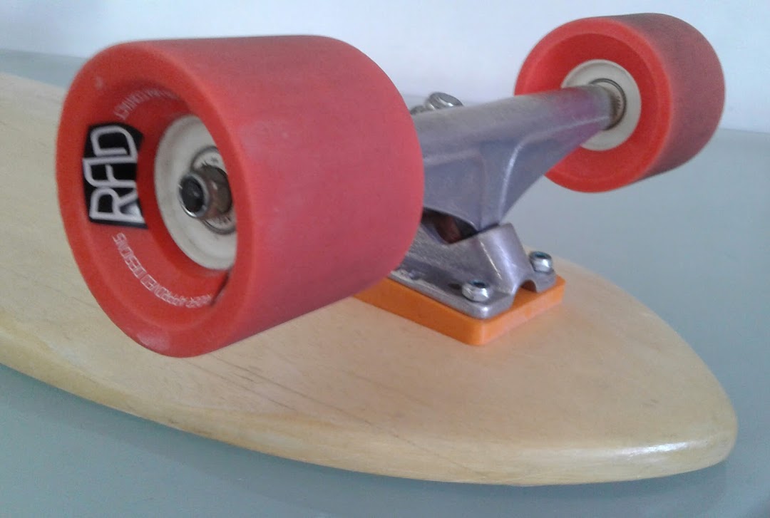 Close-up of a skateboard deck with red RAD wheels and silver trucks.