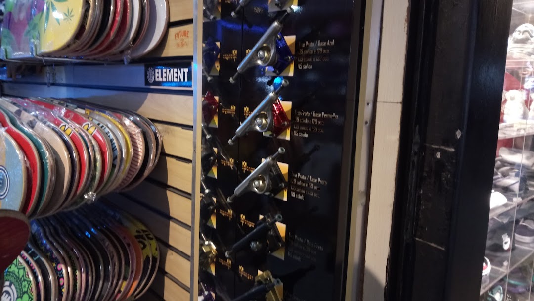 Skate shop interior displaying various skate decks and trucks on shelves and a display board.