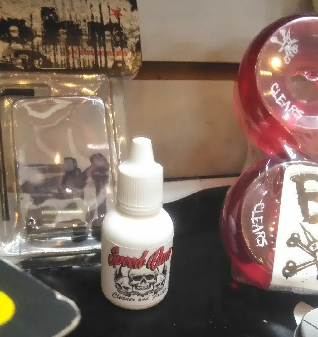 A bottle of Speed Gum cleaner and a package of red skateboard wheels.