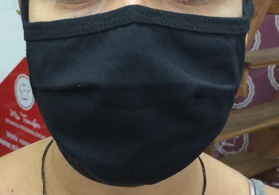 Close-up of a person wearing a black fabric face mask with the shop name 'Mix Transfer' visible.