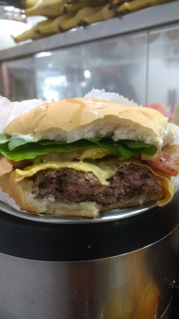 A close-up shot of a delicious burger with a thick patty, melted cheese, lettuce, and bacon.