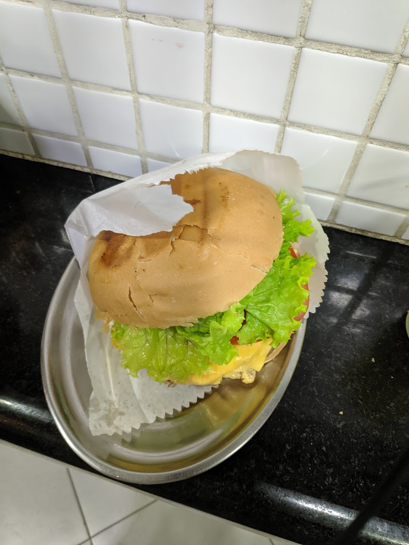 A delicious-looking burger with fresh lettuce and melted cheese, served on a metal plate.