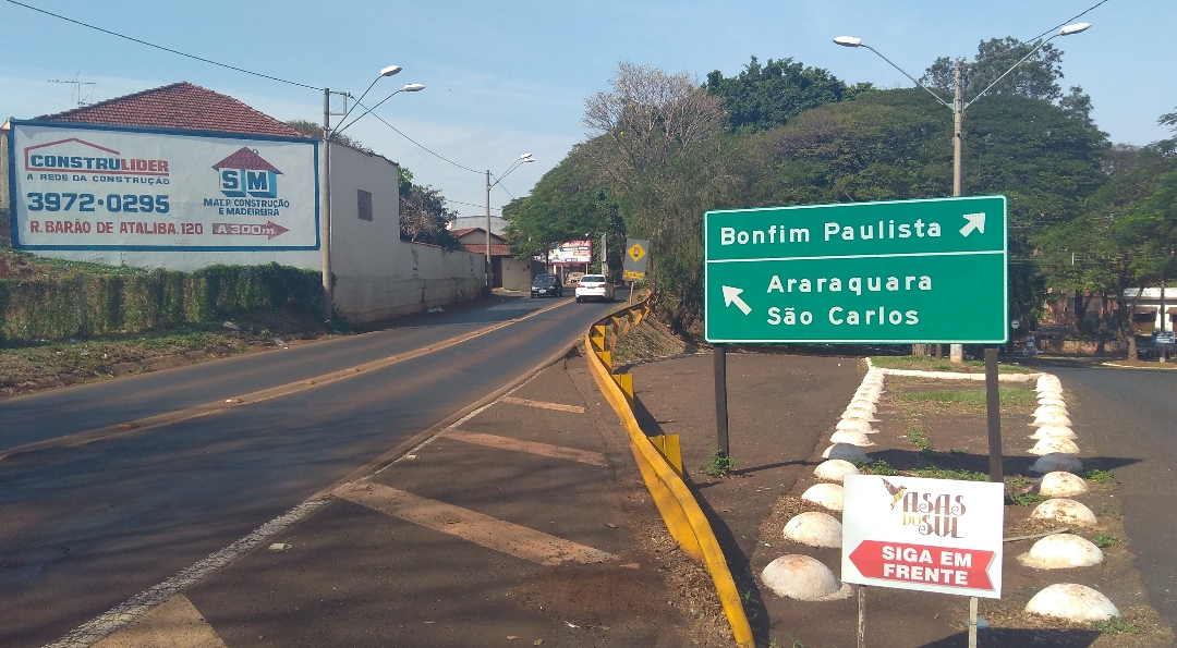 Roadside view with directional signs and advertisements for construction services.