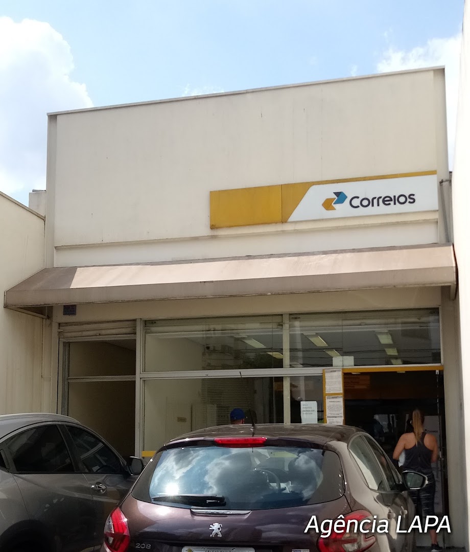 The exterior of a Correios post office with cars parked in front.