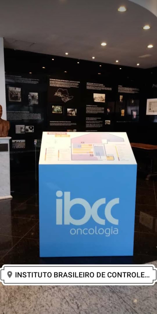 A blue informational stand with the IBCC Oncologia logo and a floor plan inside a building.
