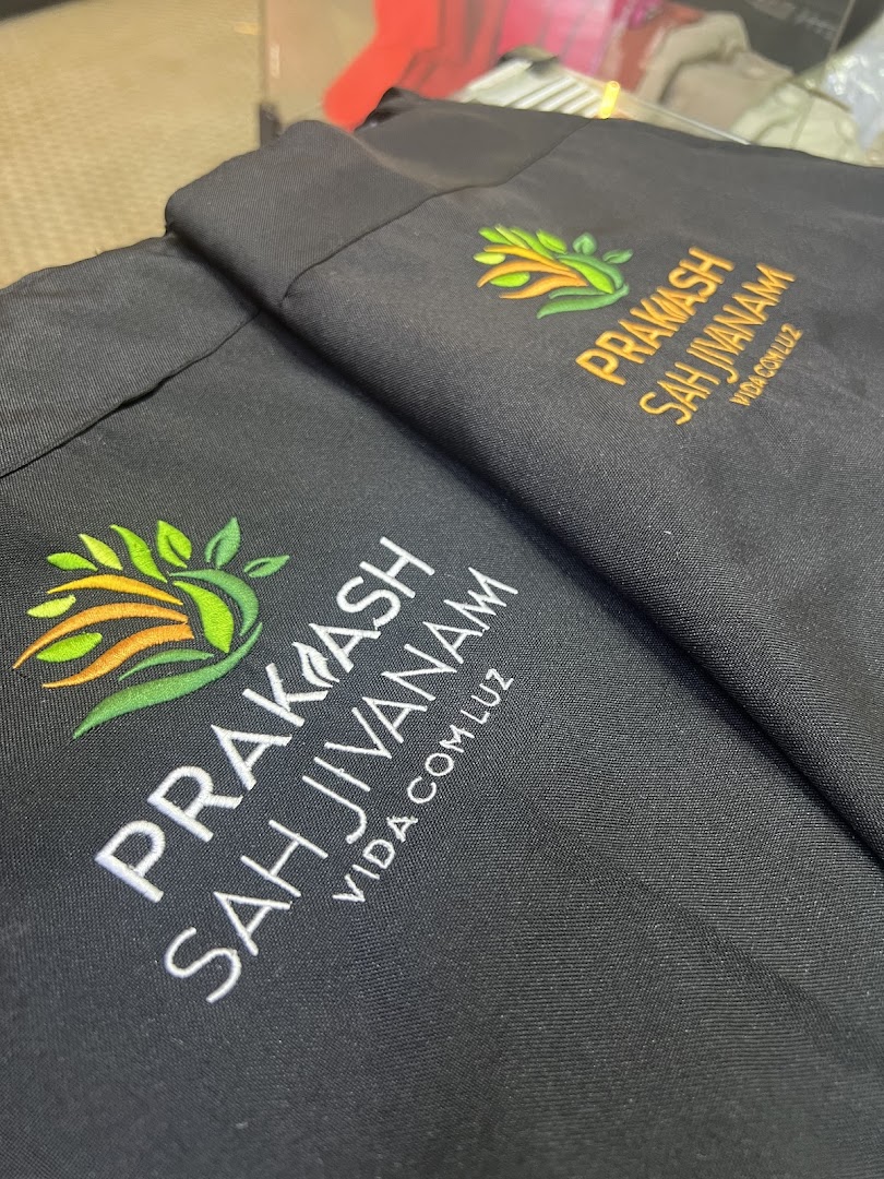 Close-up of black fabric with embroidered logos and text.