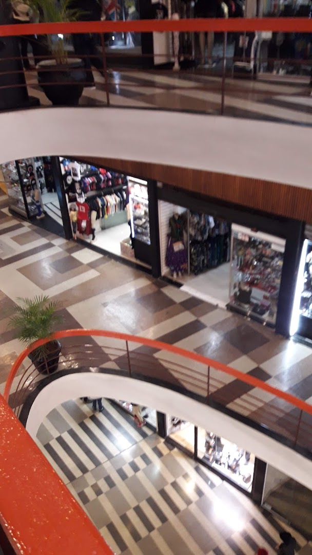 View of multiple shops on different levels of a mall, showcasing clothing and accessories.