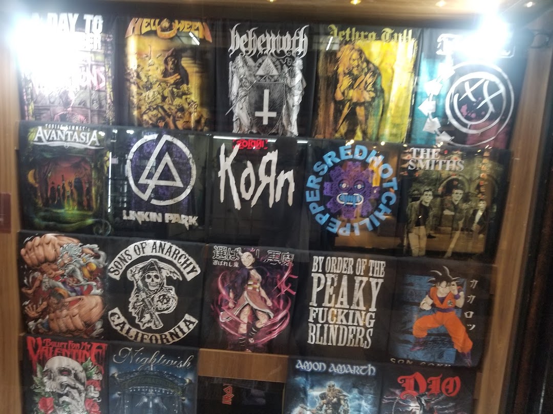 A display of band and anime t-shirts featuring various popular artists and characters.