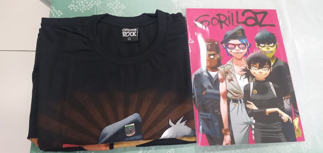 A black t-shirt with a graphic print and a Gorillaz comic book.