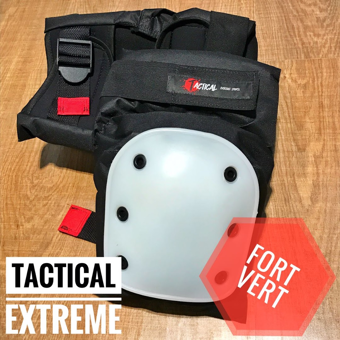 Close-up of black tactical knee pads with white protective caps and red accents.