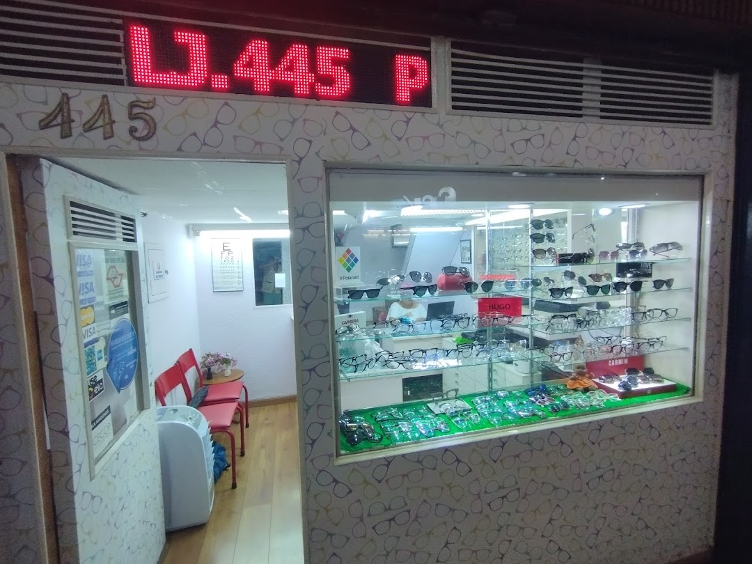 A shop front displaying a wide variety of eyeglasses in a well-lit display window.