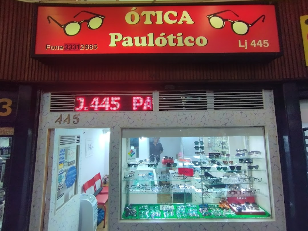 The storefront of Paulótico, an optical shop, displaying various eyeglasses in its window.