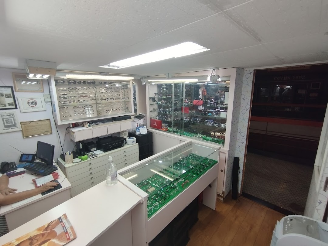 Interior view of an optical shop with display cases filled with eyeglasses and a reception desk.