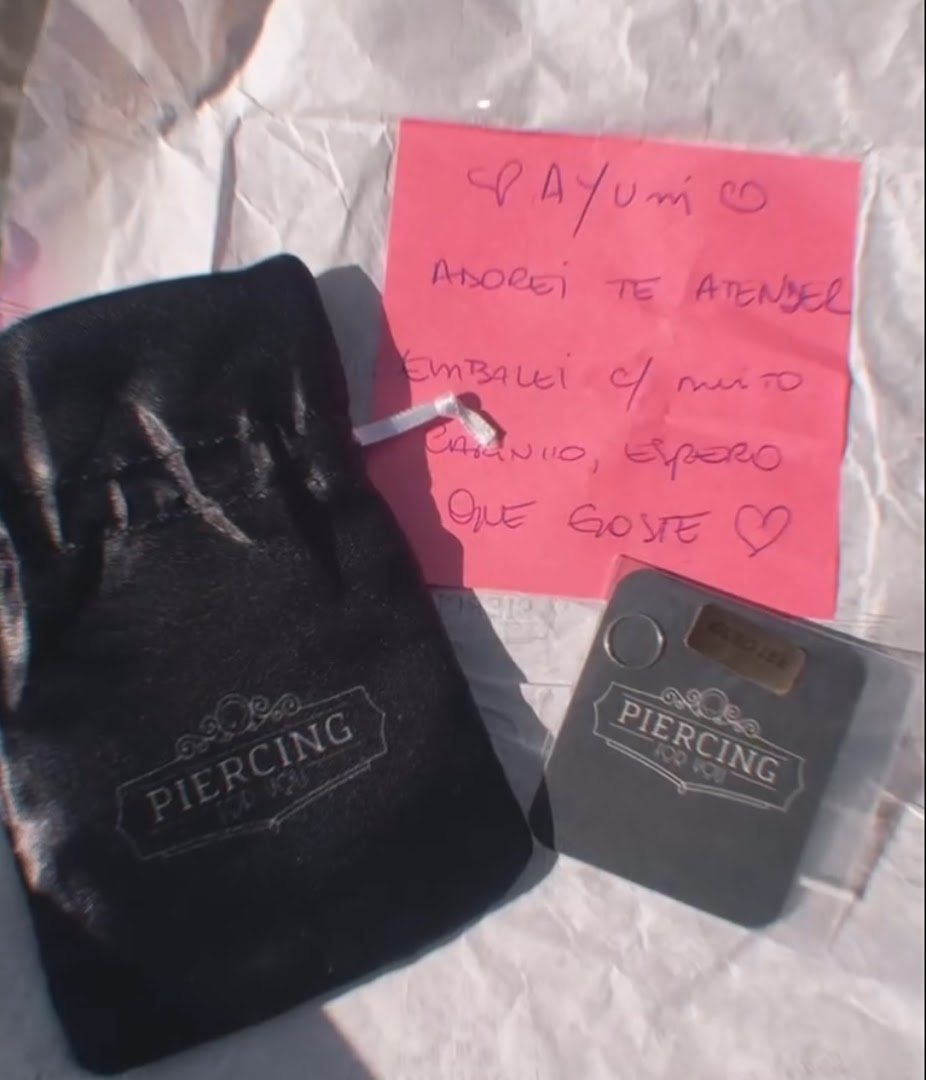 A black pouch and a small card with the shop's logo and a handwritten note.