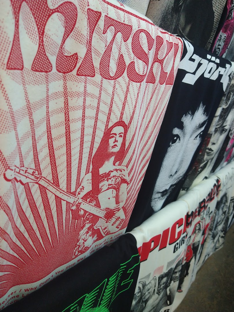 A close-up view of various band t-shirts with graphic designs and text.