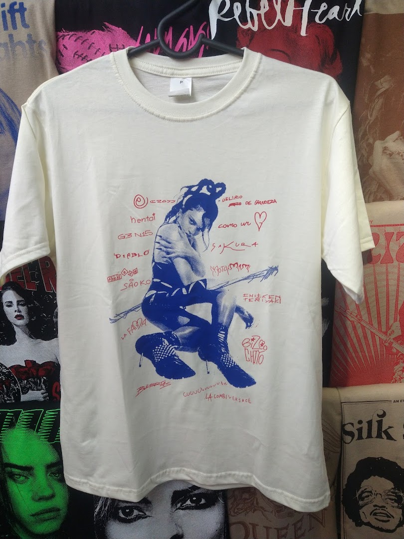 A cream-colored t-shirt with a blue graphic print of a woman and various text.