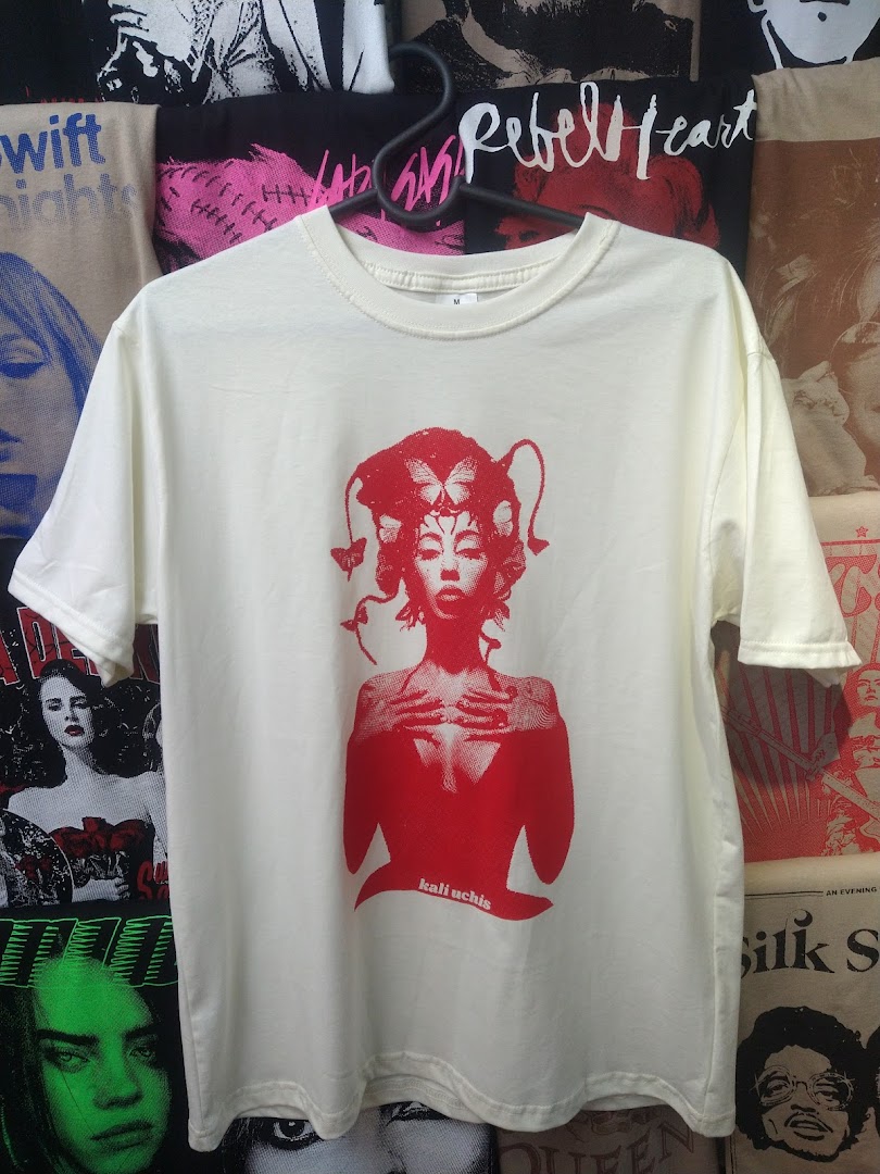 A cream-colored t-shirt with a red graphic print of a woman and butterflies.