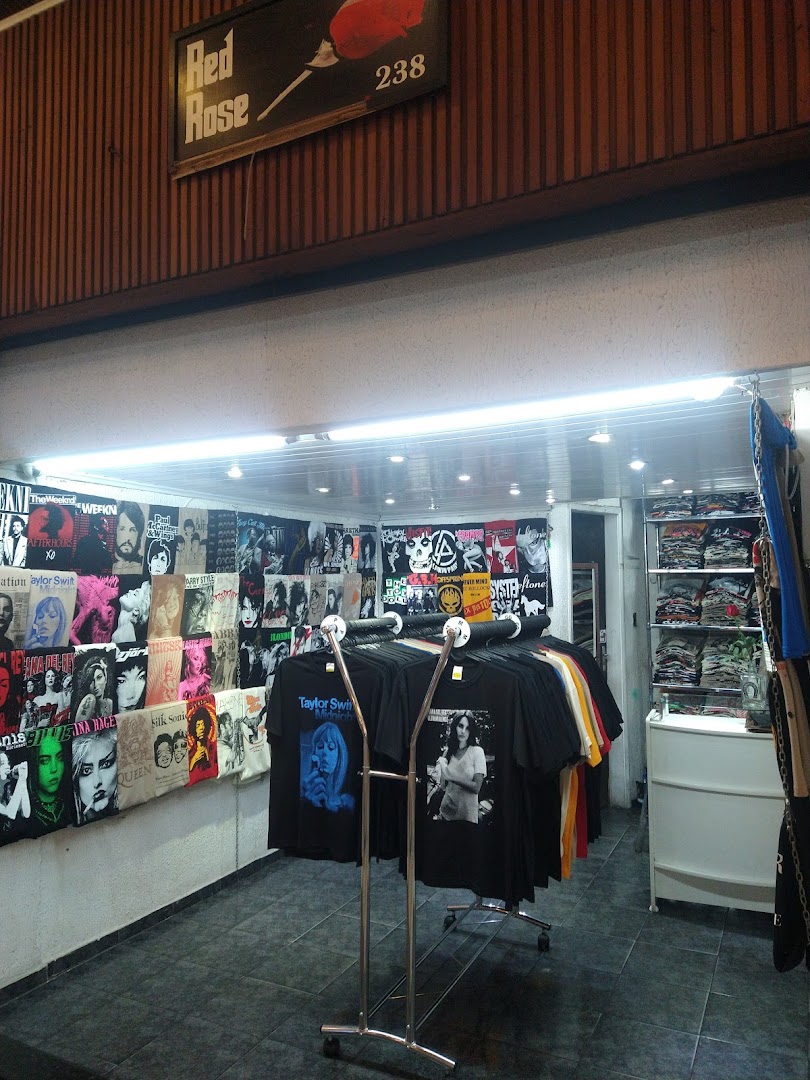 A shop interior displaying band and artist t-shirts on racks and walls.