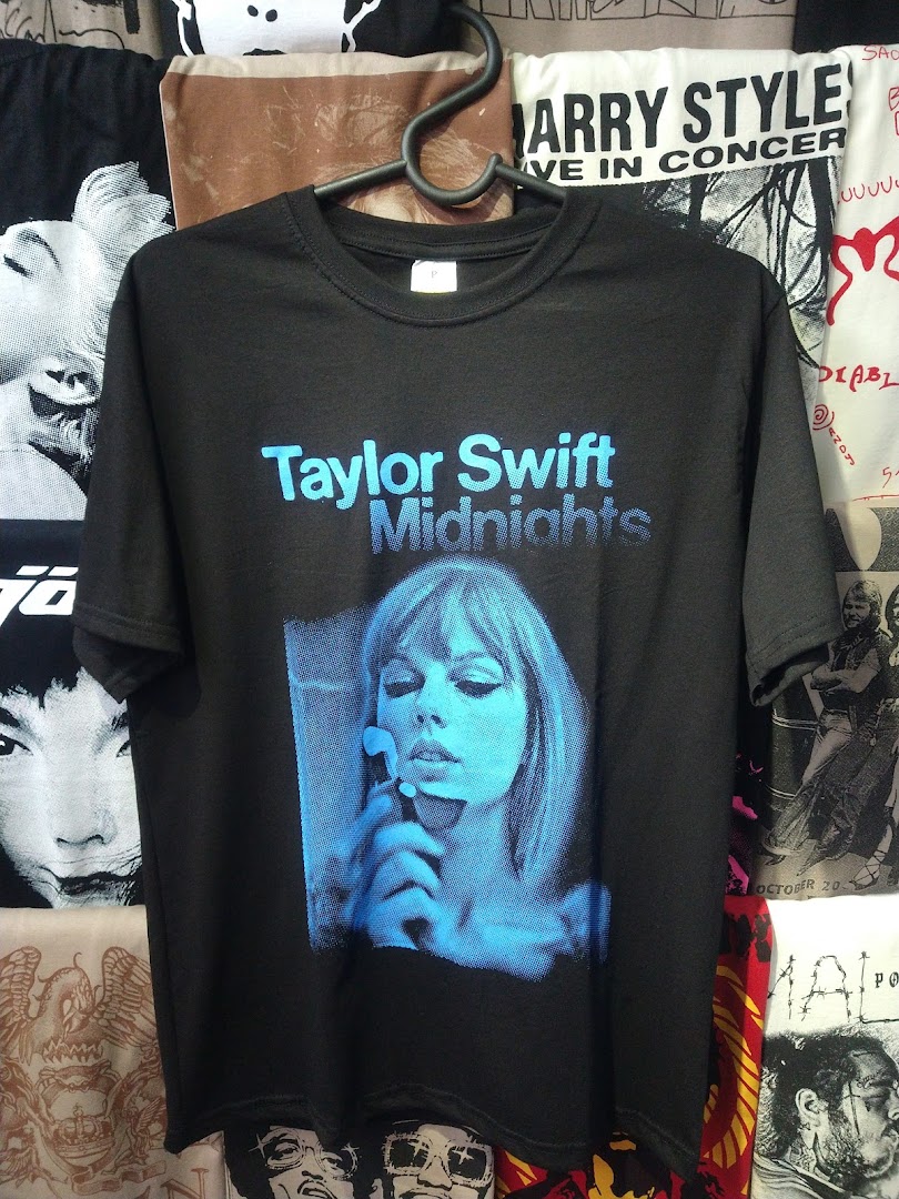 A black t-shirt featuring Taylor Swift's 'Midnights' album art is displayed.