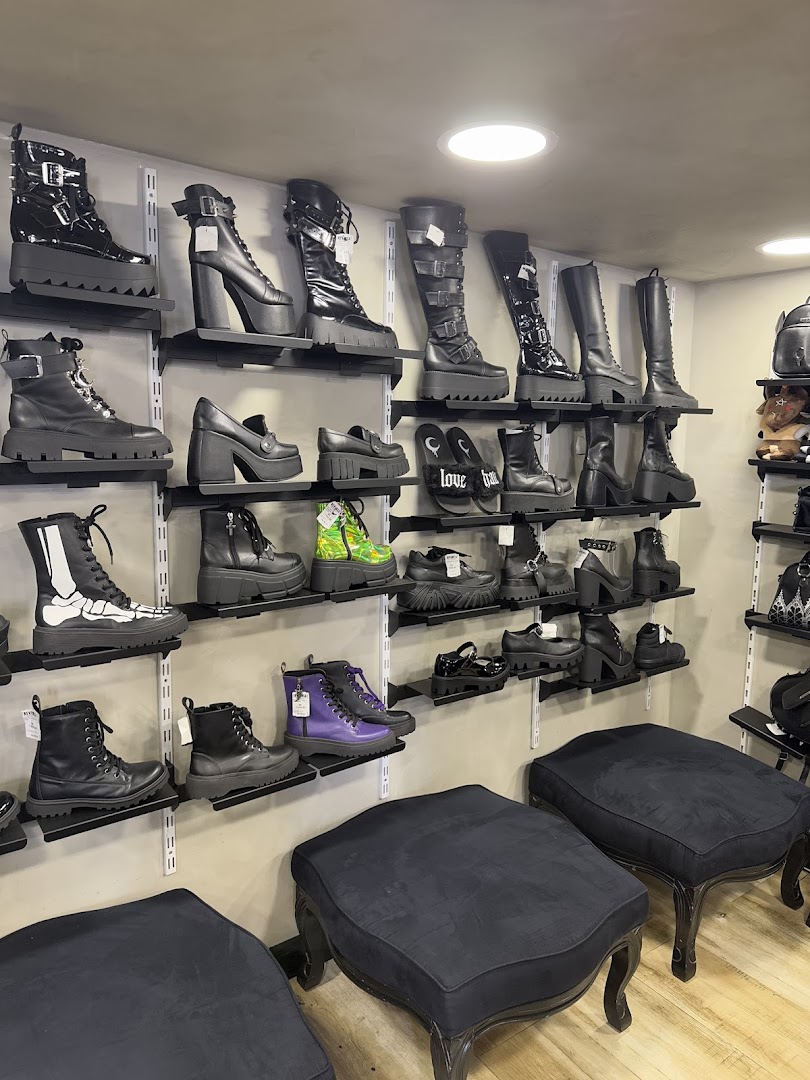 A wide selection of gothic-style platform boots and shoes displayed on shelves.