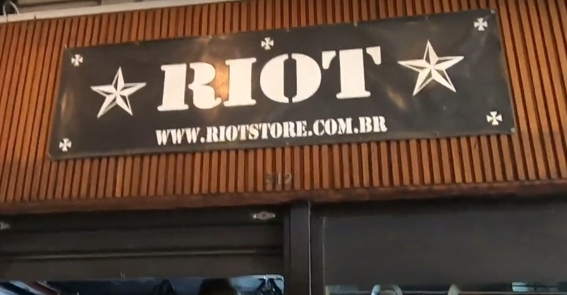 A sign for Riot Store with the website address displayed.