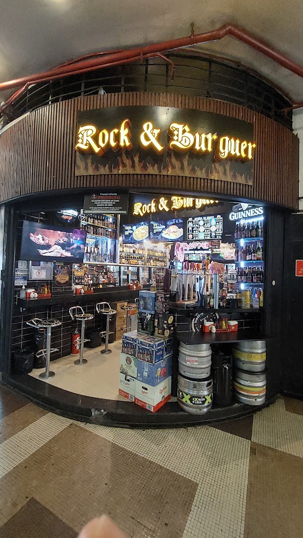 The Rock & Burguer shop front displays a vibrant selection of beers and burgers with a lively atmosphere.