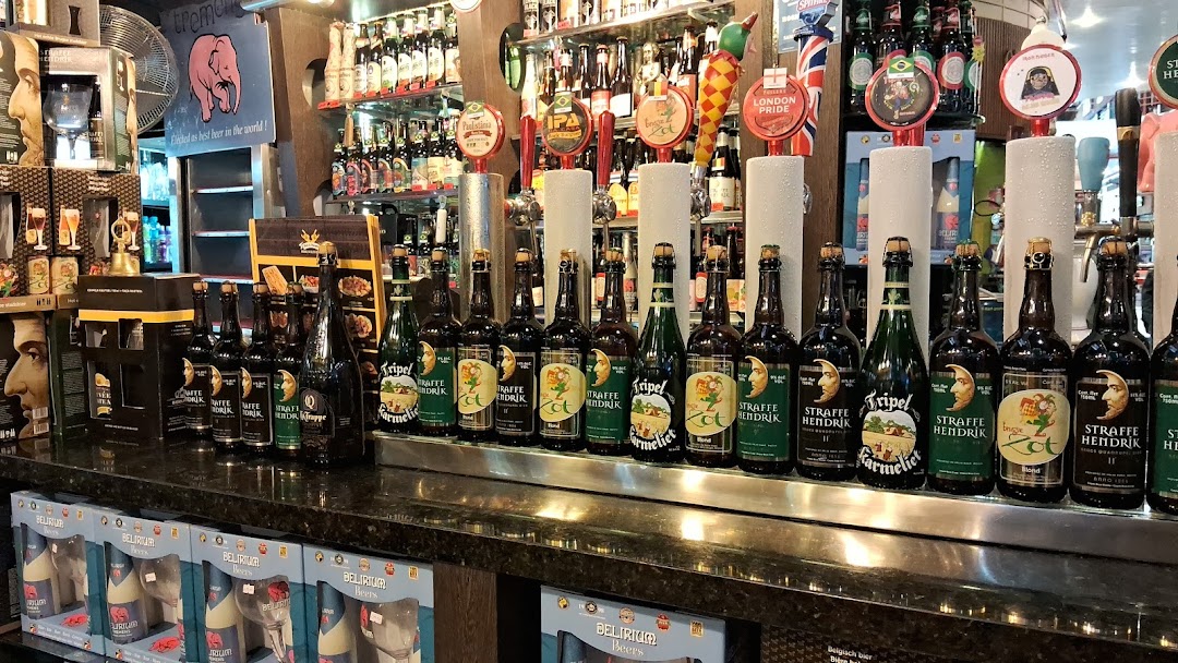 A bar counter displaying various craft beers on tap and bottled beers.