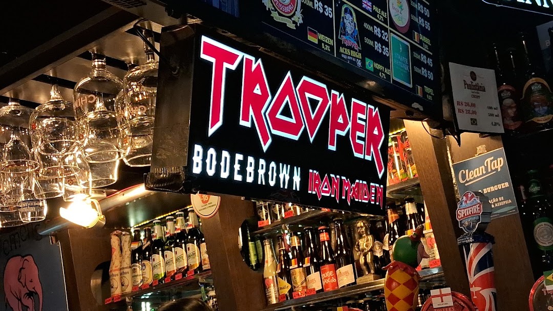 A bar counter with various beers, glasses, and a prominent "TROOPER" sign.