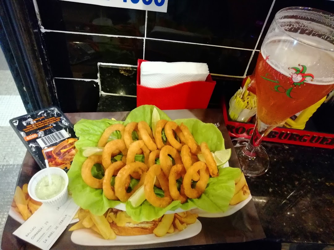 A plate of onion rings and fries served with a glass of beer at Rock Burguer.
