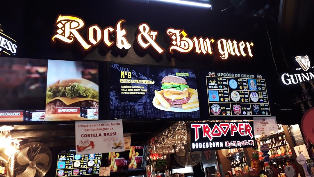 A brightly lit sign for "Rock & Burguer" with images of burgers and beer options.