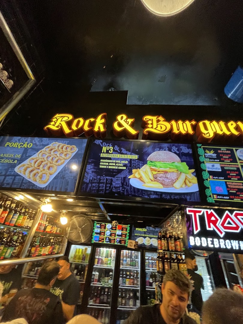 Interior view of a burger joint with illuminated signs and a display of drinks.