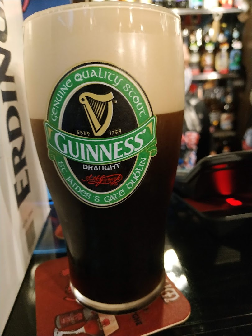 A close-up shot of a Guinness beer with its iconic logo on the glass.