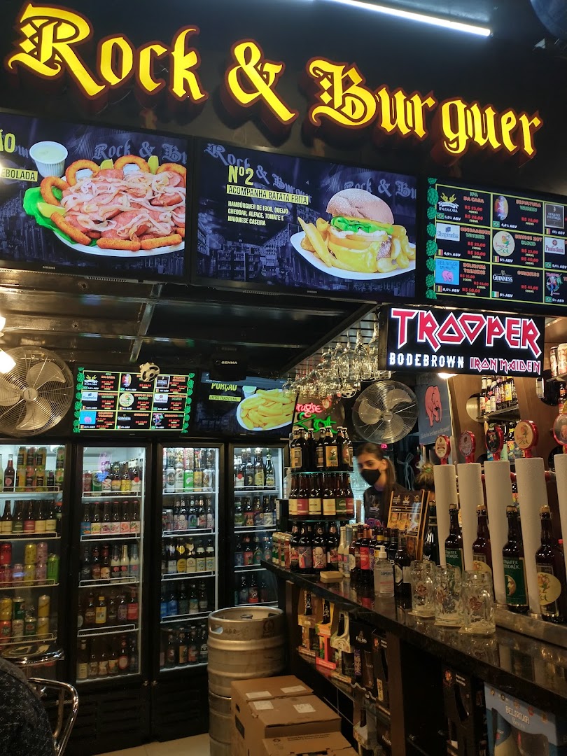 Interior view of Rock & Burguer with food displays, drinks, and a bar.