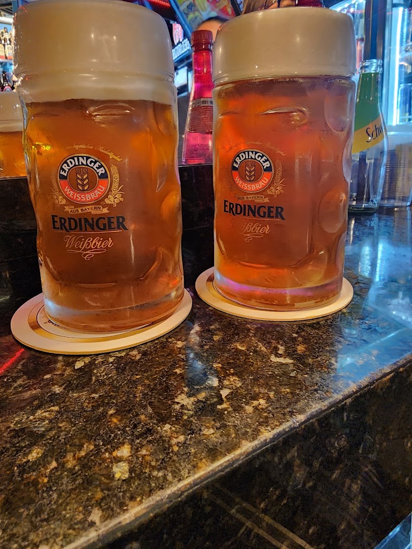Two large glasses of Erdinger Weissbier on a bar counter.
