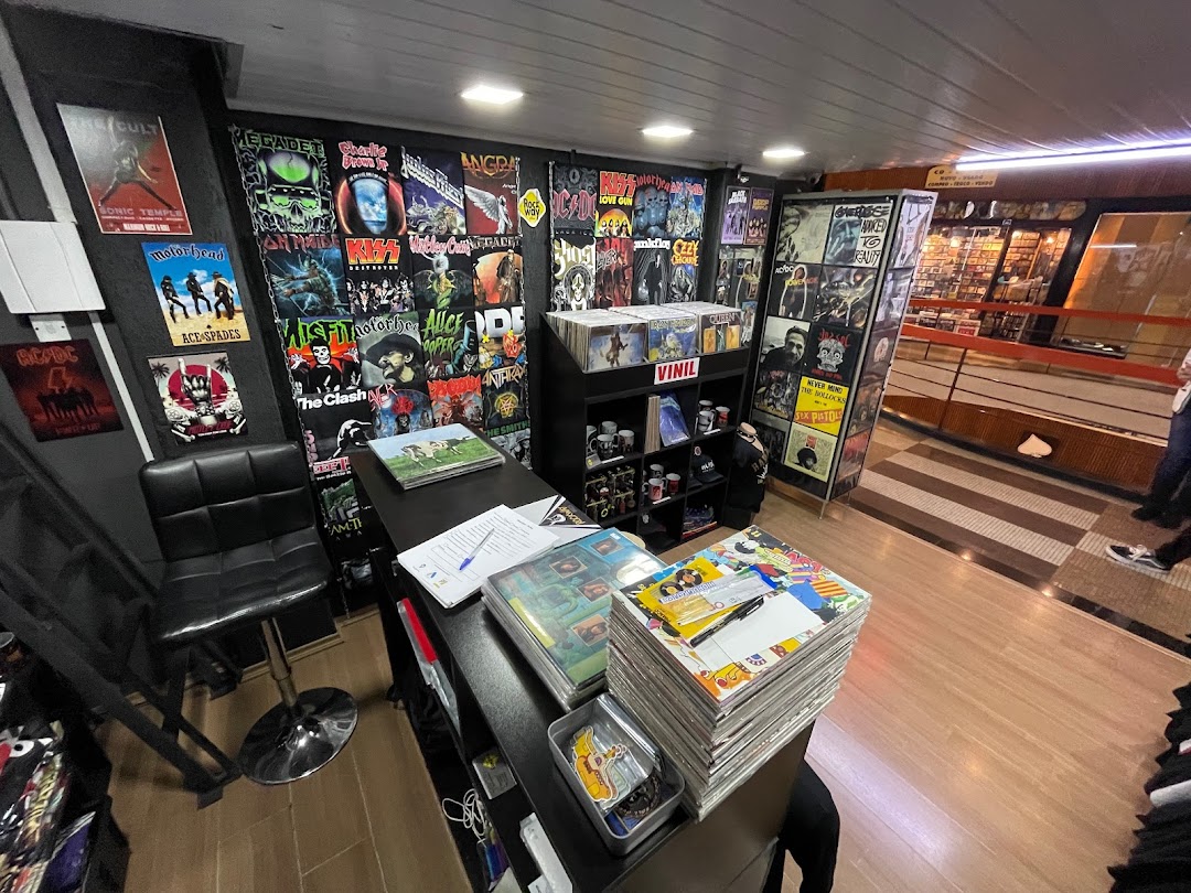 Interior of a shop selling band t-shirts and vinyl records, with posters on the walls.