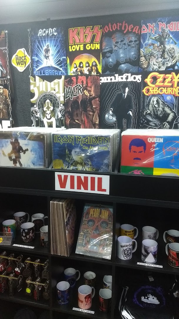 A display of band merchandise including vinyl records, t-shirts, and mugs.