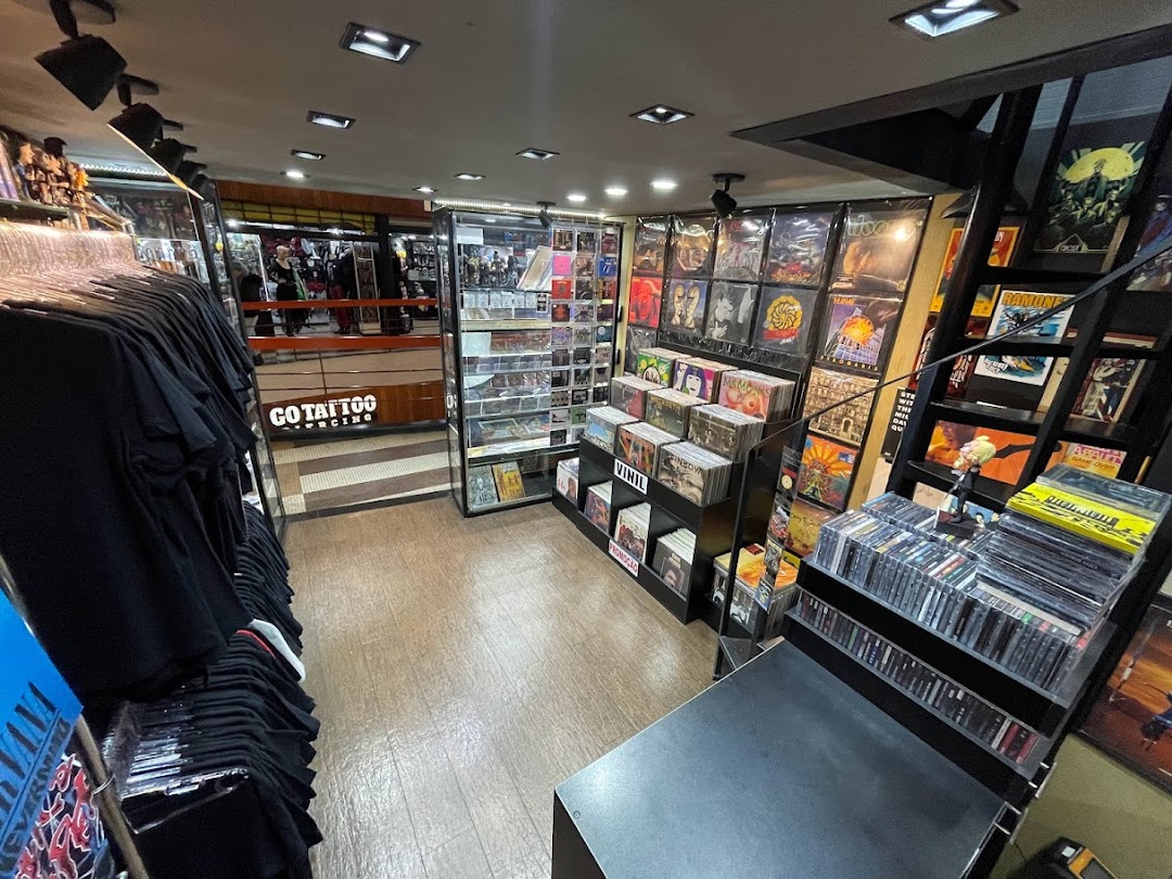 Interior view of a store selling band t-shirts and vinyl records, with displays of merchandise.