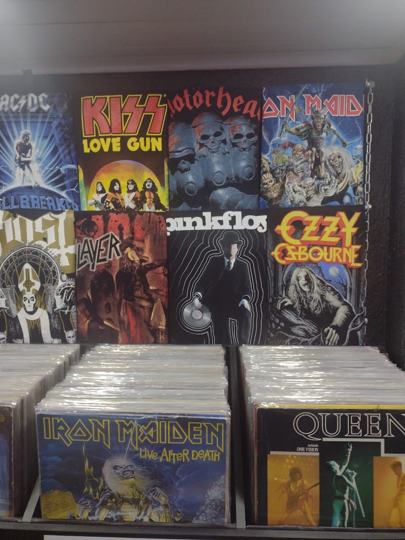A display of vinyl records and band t-shirts featuring iconic rock and metal artists.