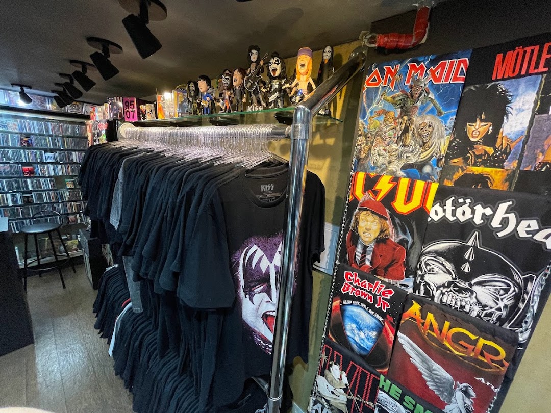 A store interior filled with band t-shirts and music memorabilia, including figures and CDs.