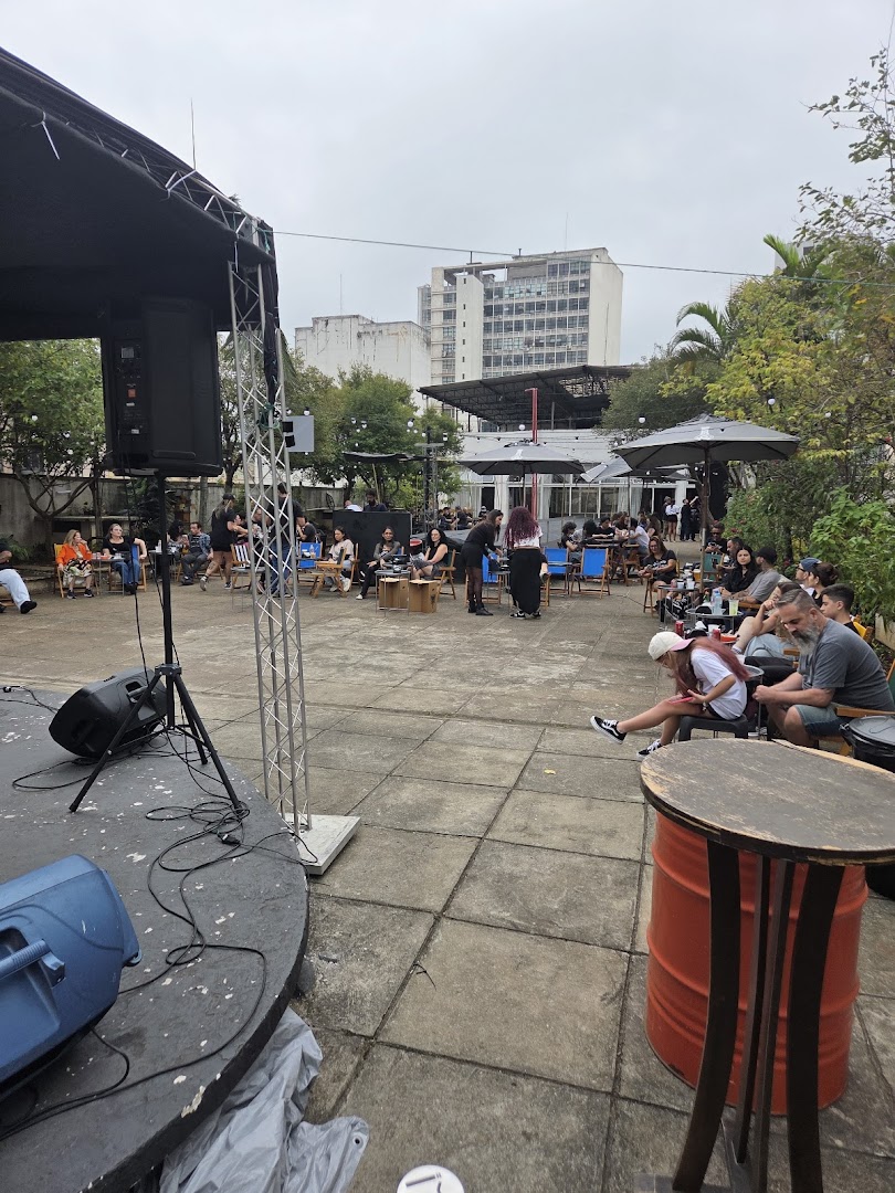 An outdoor gathering with a stage, seating, and people enjoying themselves.