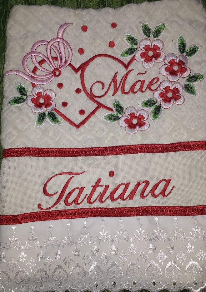 A white towel with red embroidery of a heart, flowers, and the name Tatiana.