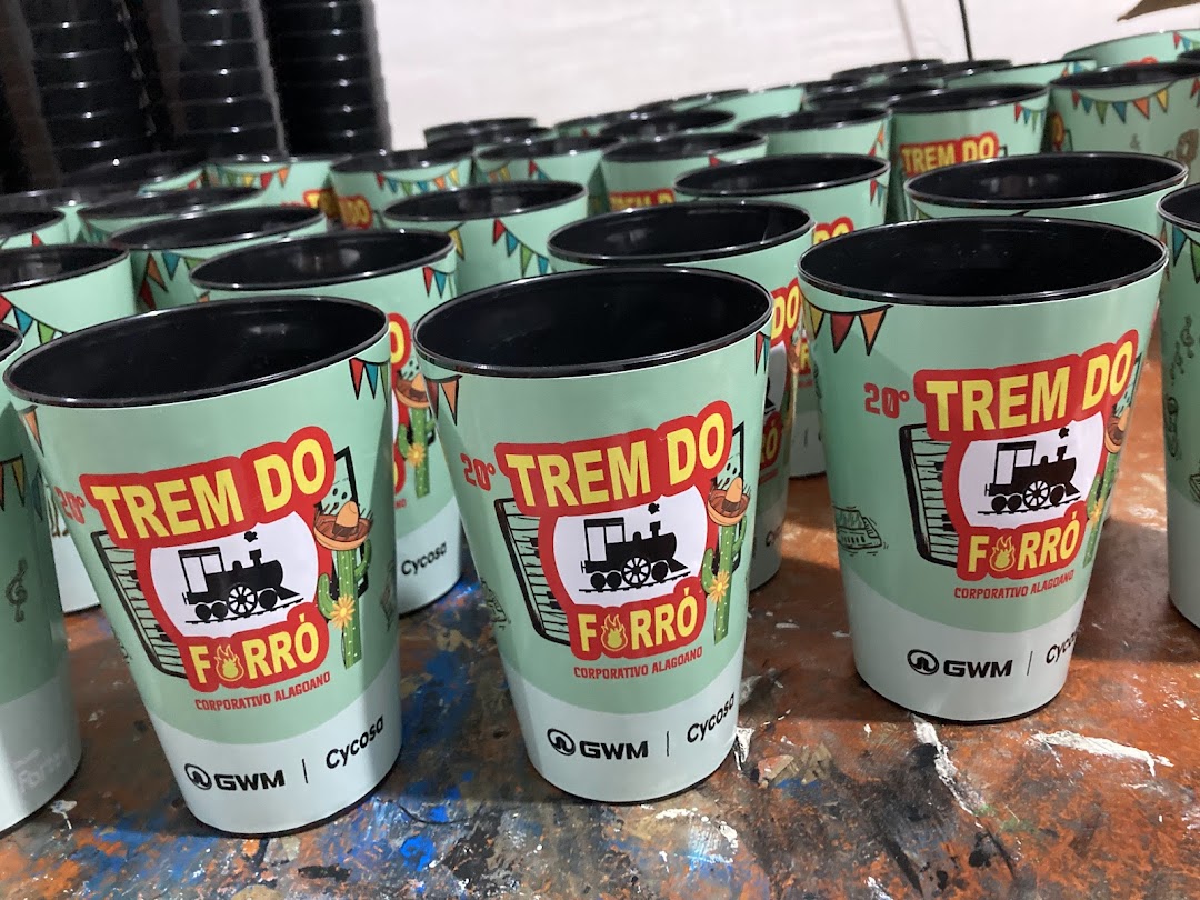 A collection of personalized cups with a train and festive design, ready for an event.