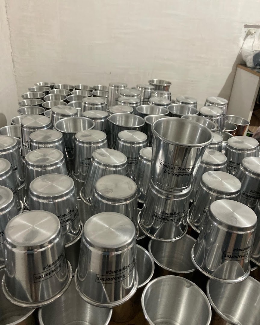 A large collection of personalized metal cups stacked together, some with branding visible.